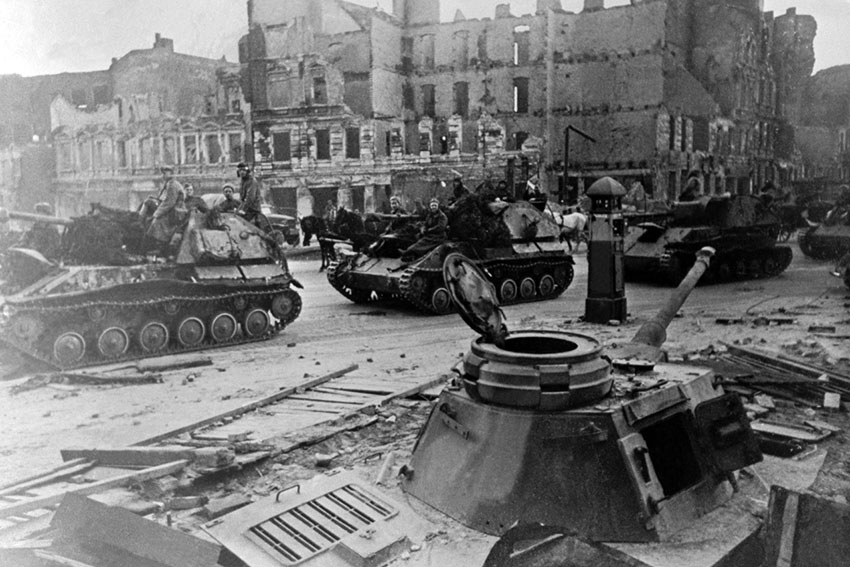 Советская самоходная пушка Су-76м проезжает мимо немецкого...
