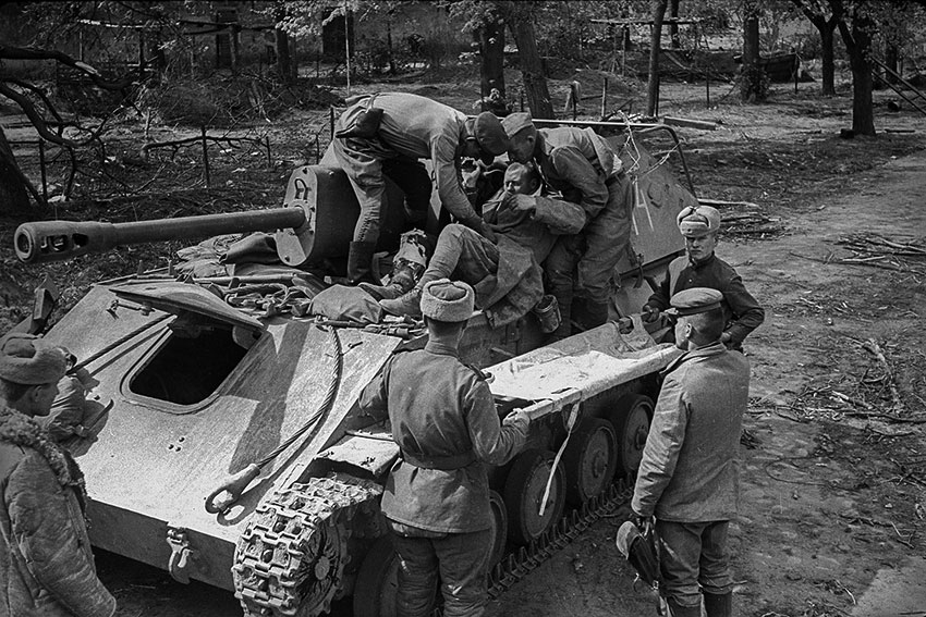 Раненого советского бойца перекладывают с САУ СУ-76М на...