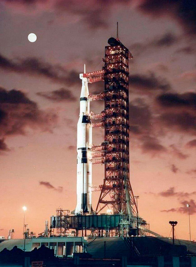 Ракета Saturn V на стартовой площадке на рассвете, незадолго... Ракета Saturn V на стартовой площадке на рассвете, незадолго...