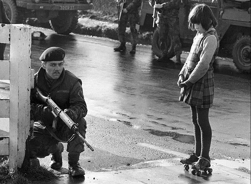 Ирландская девочка наблюдает за британским солдатом во... Ирландская девочка наблюдает за британским солдатом во...