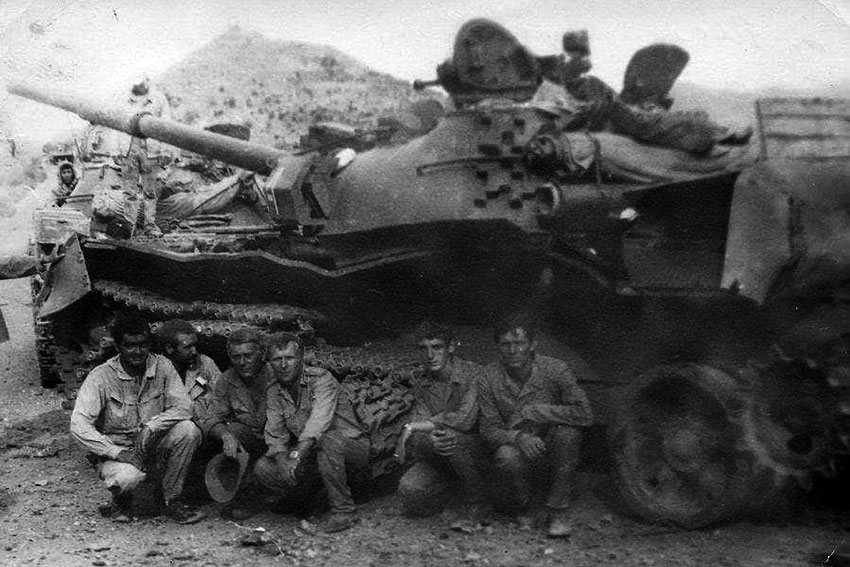 Советские военнослужащие позируют на фоне уничтоженного...
