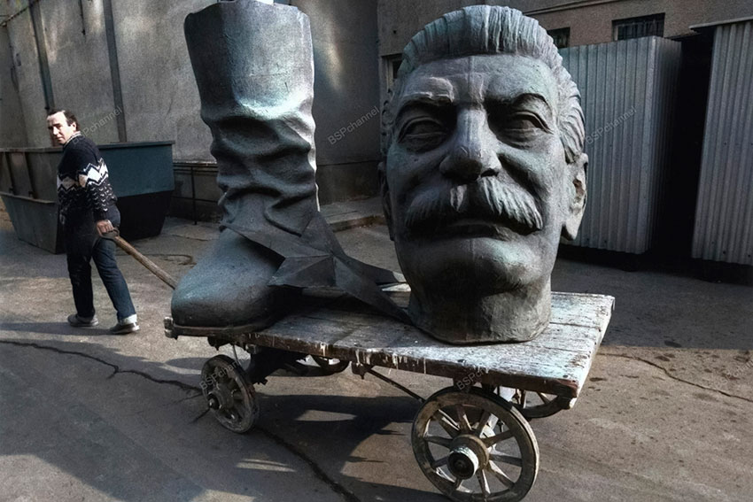 Мужчина тащит части статуи Сталина после того, как было... Мужчина тащит части статуи Сталина после того, как было...